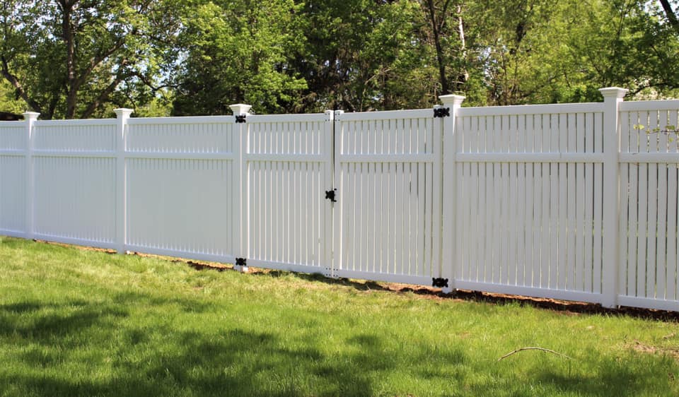 Photo of a semi-private white vinyl picket fence